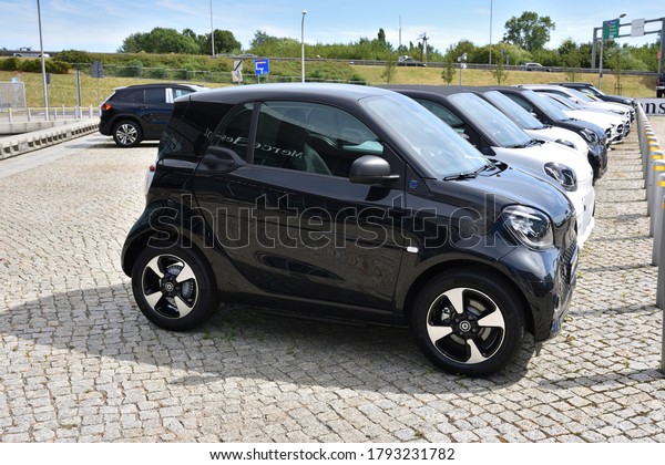 Smart\
cars, row of German microcars, exposition near Mercedes-Benz\
Warszawa building. WARSAW, POLAND - AUGUST 2,\
2020