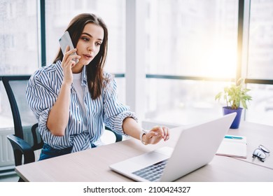 Smart casual female employee using smartphone app for making service consultancy during laptop programming in modern workspace, Caucasian woman connecting to 4g for phoning and call talking via mobile - Powered by Shutterstock