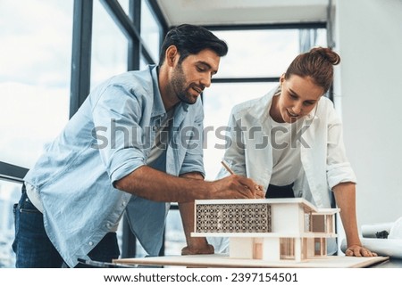 Smart caucasian architect engineer team working together to measure house model. Group of professional interior designer brainstorming and sharing ideas about design building construction. Tracery.