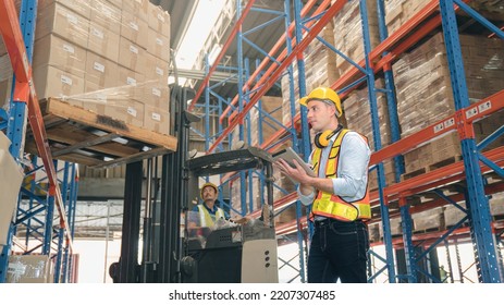 Smart Caucasian Warehouse Man,manager Use Digital Tablet Check Package With Worker Forklift Driver Loading Box On Shelf, Product Distribution Inventory Management, Logistics Shipping Business Planning