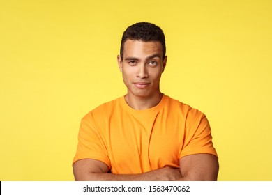 Smart and cheeky handsome sexy guy in t-shirt, cross arms chest, raise one eyebrow skeptical or suspicious, dont buy friend lie, smiling as have assumptions, express disbelief, yellow background