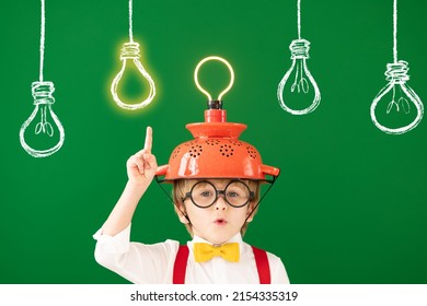 Smart child in the class against blackboard. Funny kid with lightbulb at school. Education, start up and business idea concept