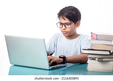 Smart Child Using Laptop For Online Education With Some Books On Desk