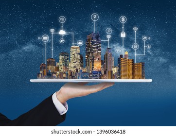 Smart City, Building Technology, And Real Estate Business. Businessman Holding Digital Tablet With Buildings Hologram And Application Programming Interface Technology