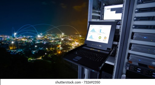 smart city concept. monitor show graph information of network traffic and status of device in the server room of the data center and blending with cityscape panorama of Phuket city, Thailand at night