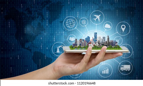 Smart city model on smartphone in women's hand holding with Abstract Blue Technology Background and world map. Binary Computer Code.