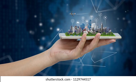 Smart city model on smartphone in women's hand holding with Abstract Blue Technology Background and world map. Binary Computer Code.