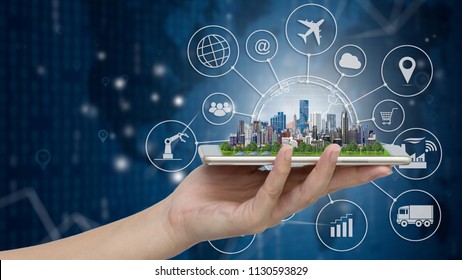 Smart City Model On Smartphone In Women's Hand Holding With Abstract Blue Technology Background And World Map. Binary Computer Code.