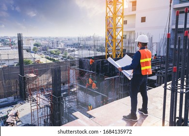 Smart civil architect engineer inspecting and working outdoors building side with blueprints. engineering and architecture concept.