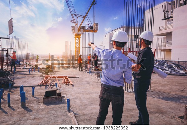 Smart civil architect engineer inspecting and\
working outdoors structure building site with blueprints.\
engineering and architecture\
concept.