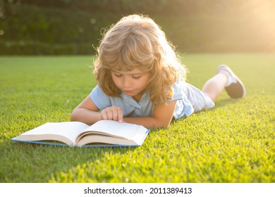 Smart Clever Kids. Cute Lovely Child Reading Book Outside. Kid Read Book In Park. Summer Outdoor Kids Education.