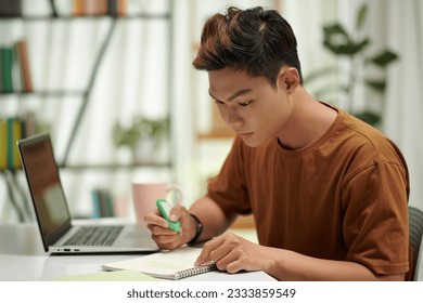 Smart computer science student reading lecture notes he took during class - Powered by Shutterstock