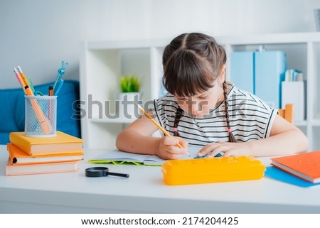 Smart concentrated small 7s years Caucasian girl child sit desk home study distant do homework with textbooks. Pensive little kid handwrite learn preparing school task assignment. Education concept.