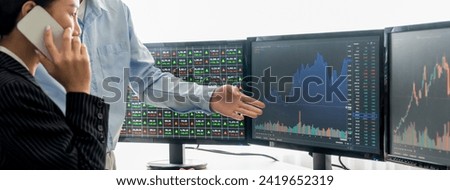 Smart cooperative male trader points the growth analysis stock market graph displayed on computer to investor. Asian businesswoman calling her customers. Stock market investment concept Burgeoning.