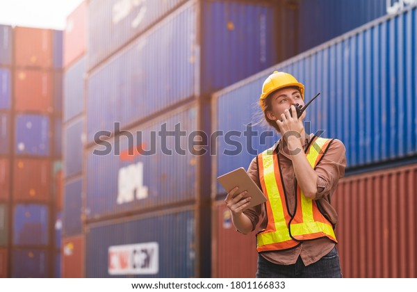 Smart creative engineer woman using digital tablet\
control loading containers box from cargo freight ship for import\
export. Logistic, Transportation, import and export concept. with\
copy space