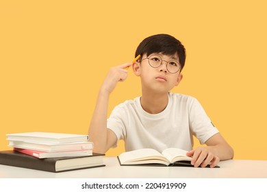 Smart and cute student who thinks carefully, concentrates and studies hard is learning at his desk.
 - Powered by Shutterstock