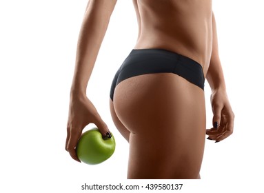 Smart dieting. Closeup cropped shot of a fit and toned female holding an apple showing off her gorgeous body and perfect buttocks