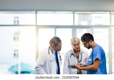 Smart doctors use smart apps. Shot of a team of doctors using a digital tablet together in a hospital. - Powered by Shutterstock