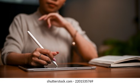 Smart and elegant Asian businesswoman or female boss using a digital tablet touchpad to take notes and plan her work. - Powered by Shutterstock