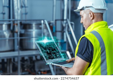 Smart engineer worker using software on laptop to monitor check factory boiler pipe valve control system
