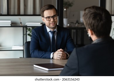 Smart experienced young businessman job seeker in formal attire sit at desk in potential employer office pass interview answer hr recruiter question. Two millennial business partners hold negotiations - Powered by Shutterstock