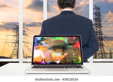 Smart Factory Or Industrial 4.0 Concept Background. Laptop Computer With Smart Factory Image On Its Screen Against The Power Transmission Line Outside Building Background.