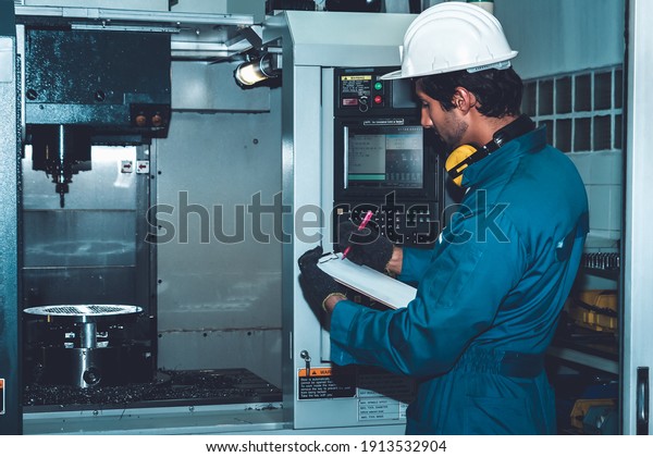 Smart factory worker\
or engineer do machine job in manufacturing workshop . Industry and\
engineering concept .