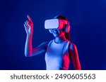 Smart female stand with surrounded by cyberpunk neon light wear VR headset connecting metaverse, futuristic cyberspace community technology. Woman using finger pointing virtual object. Hallucination.