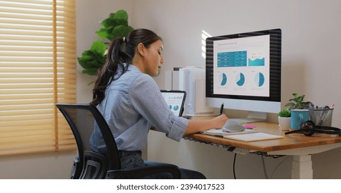 Smart Gen Z tech talent workforce typing SEO sale report on desktop PC happy work easy relax at home office. Remote WFH reskill upskill job MBA study of young people asia woman examine big data graph. - Powered by Shutterstock