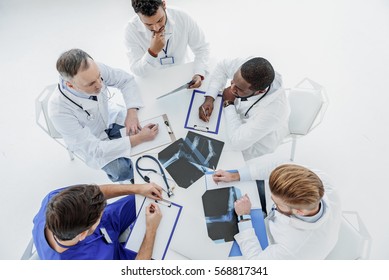 Smart general practitioners having conversation at desk Stock Photo