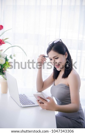 smart girl's using smart phone and working on laptop ,happy time on work, smile and laughing time work , workingwomen get think about work