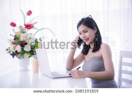 smart girl's using smart phone and working on laptop ,happy time on work, smile and laughing time work , workingwomen get think about work online selling