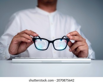 Smart glasses. Businessman in white shirt holding smart glasses with digital information on virtual screen high tech interface. Futuristic technology and augmented reality concept.