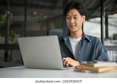 Smart and handsome young Asian male office worker or college student remote working at the coffee shop, using laptop and focusing on his project. - Powered by Shutterstock