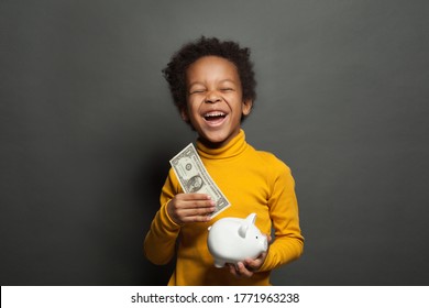 Smart Happy Black Child Boy Putting In Piggy Bank One Dollars Banknote