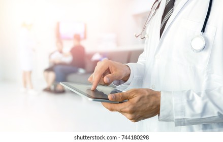 Intelligente Internet-Gesundheitsfürsorge von Dingen und Automatisierungstechnologie im Krankenhaus mit papierlosem. Arzt mit Stethoskop, der eine Tablette zur Fernüberwachung verwendet, um den Status des Patienten zu überprüfen.
