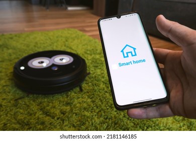 Smart Home App On Smartphone. Remote Control Of Electronic Devices In Apartment. Concept Of Controlling Smart Electronics In The House. Internet Of Things. All The Graphics On The Screen Are Made Up.