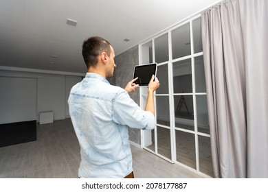 Smart Home: Man Controlling Blinds With His Tablet