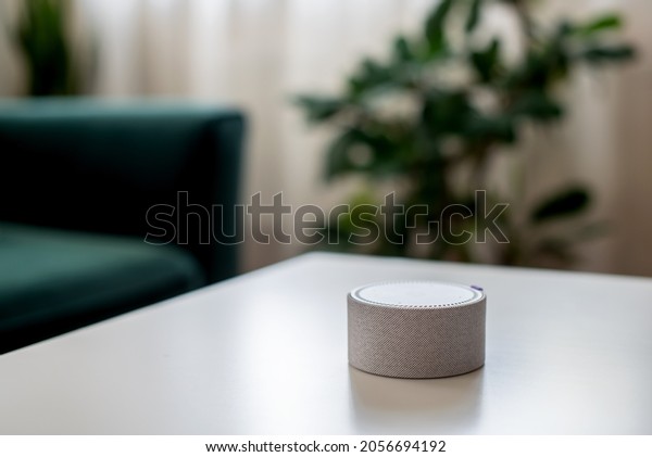 Smart home speaker device voice\
activate at white table. Wireless speaker, voice controlled smart\
speaker and personal assistant at home,\
technologies