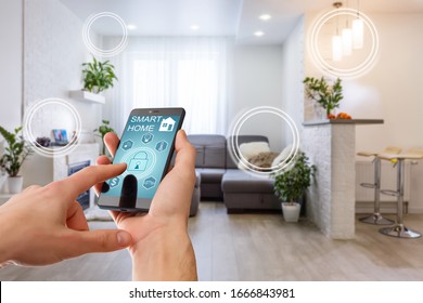 Smart Home Technology Interface On Smartphone App Screen With Augmented Reality (AR) View Of Internet Of Things (IOT) Connected Objects In The Apartment Interior, Person Holding Device