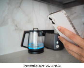 Smart Home, Woman Switch On The Kettle With  Smartphone, WiFi Kettle