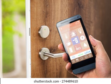 Smart House, Home Automation, Device With App Icons. Man Uses His Smartphone With Smarthome Security App To Unlock The Door Of His House.