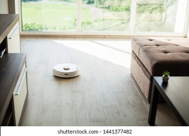 Smart House. Vacuum Cleaner Robot Runs On Wood Floor In A Living Room