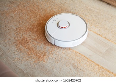 Smart House. Vacuum Cleaner Robot Runs On Wood Floor In A Living Room