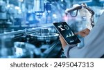 Smart industry automation manufacturing control concept.Hands holding tablet on blurred automation machine as background	
