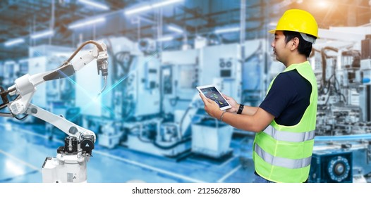 Smart Industry Control Concept.Engineer Hands Holding Tablet On Blurred Robot Arm Automation Machine As Background