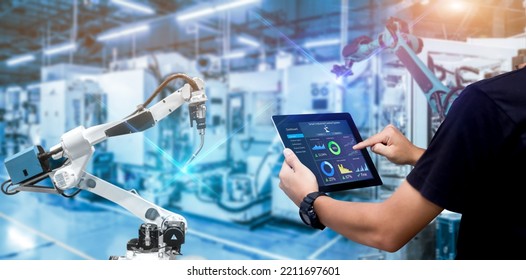 Smart Industry Control Concept.Engineer Hands Holding Tablet On Blurred Robot Arm Automation Machine As Background