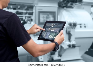 Smart Industry Control Concept.Hands Holding Tablet On Blurred Automation Machine As Background