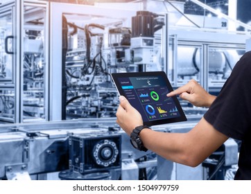 Smart industry control concept.Hands holding tablet on blurred automation machine as background - Shutterstock ID 1504979759