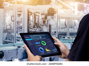 Smart Industry Control Concept.Hands Holding Tablet On Blurred Automation Machine As Background